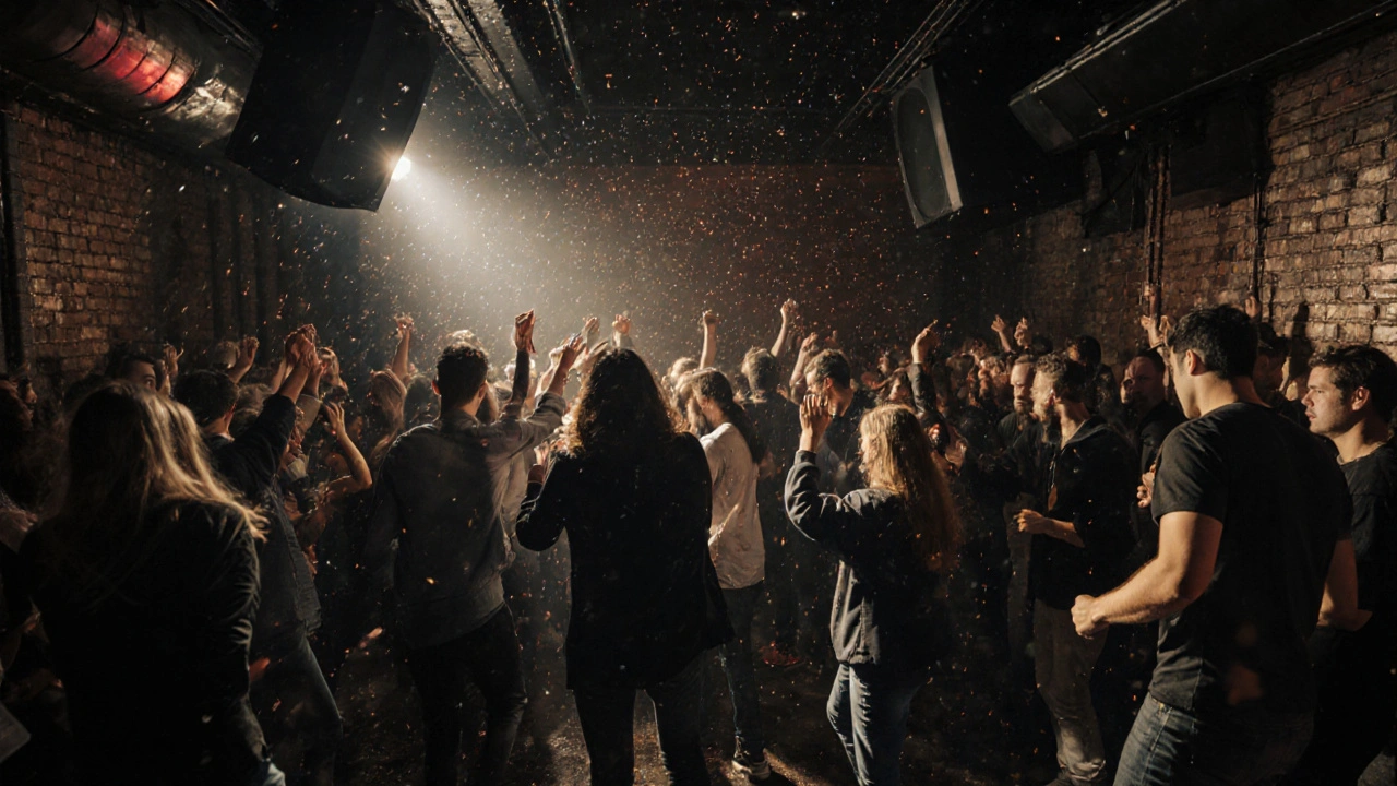 Crowd dancing energetically in a raw, industrial nightclub with pulsing lights.