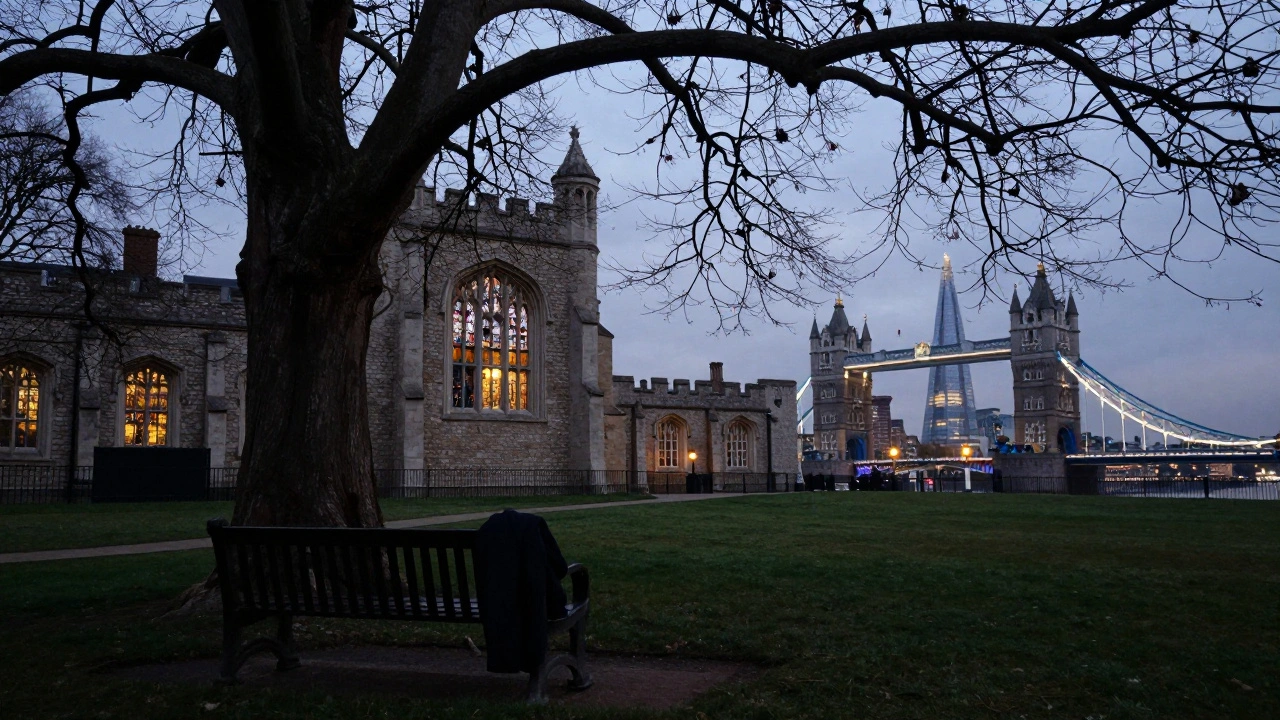 Quiet Tower Green at dusk, bench near the chapel with lanterns glowing in the distance.