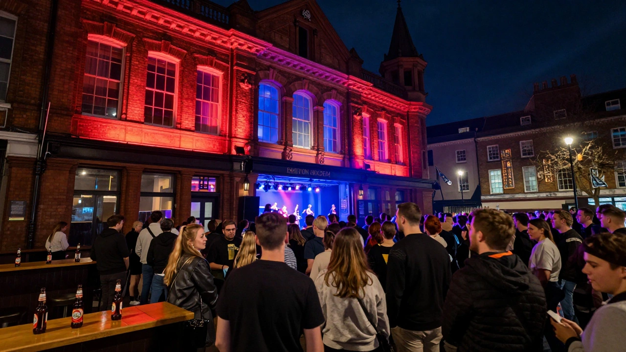 Brixton Academy at night, packed with a diverse crowd outside a historic venue glowing with stage lights.