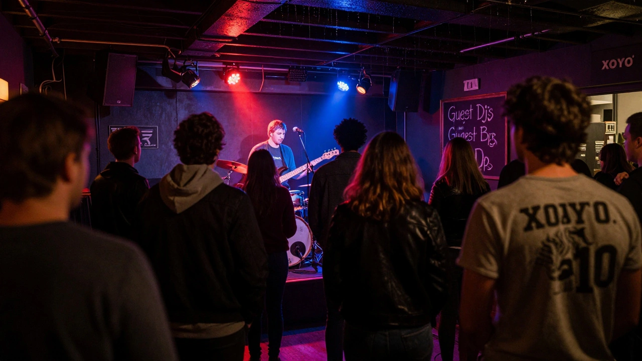 Live band performing on a low stage inside XOYO as patrons move freely under colorful stage lights.