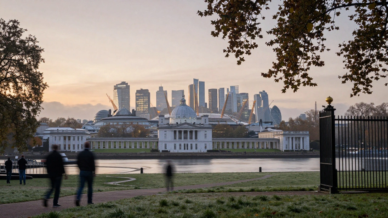 Sunrise panorama from Greenwich Park with the Royal Observatory framed by an iron gate and Canary Wharf in the distance.